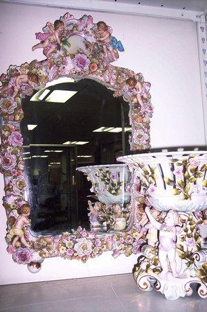 Appraisal: A Continental mirror the frame with encrusted flower decoration and