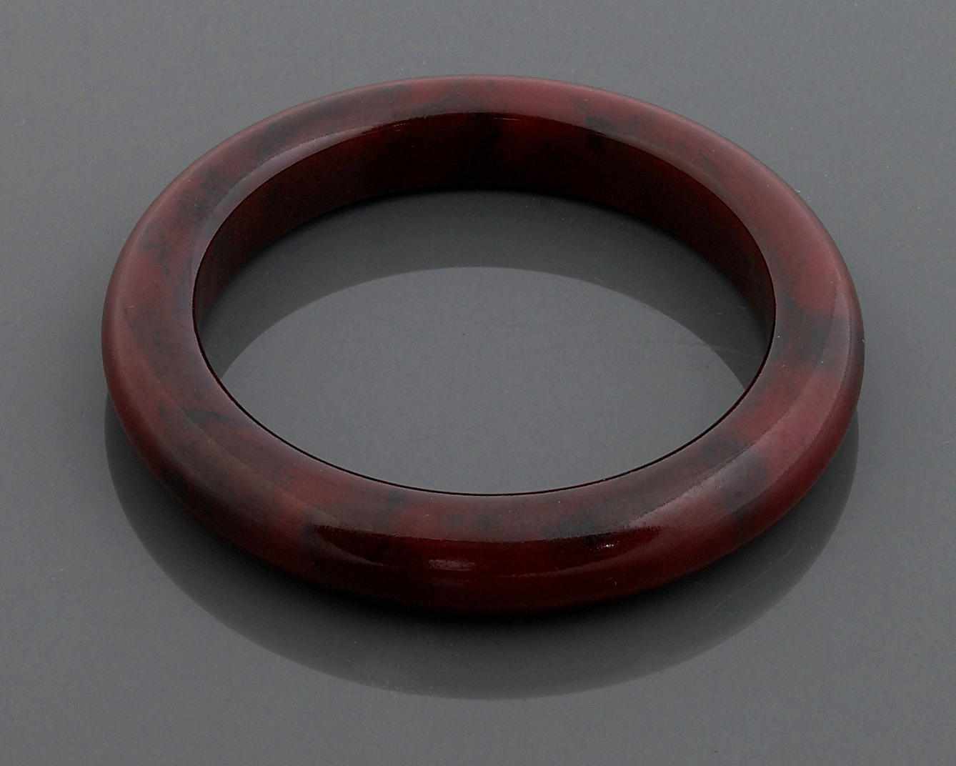 Appraisal: Property of various owners A bakelite brown-ish red bangle