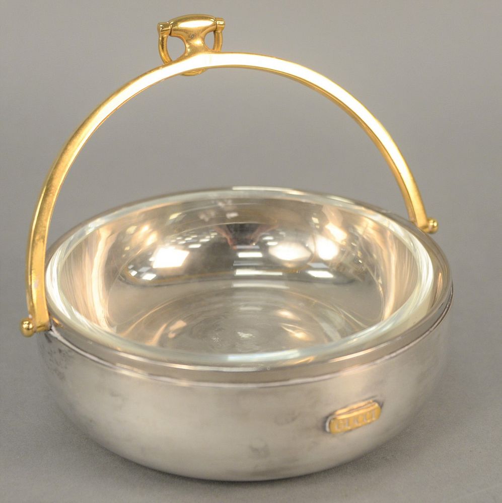 Appraisal: Gucci stainless and silver plate bowl having brass swing handle