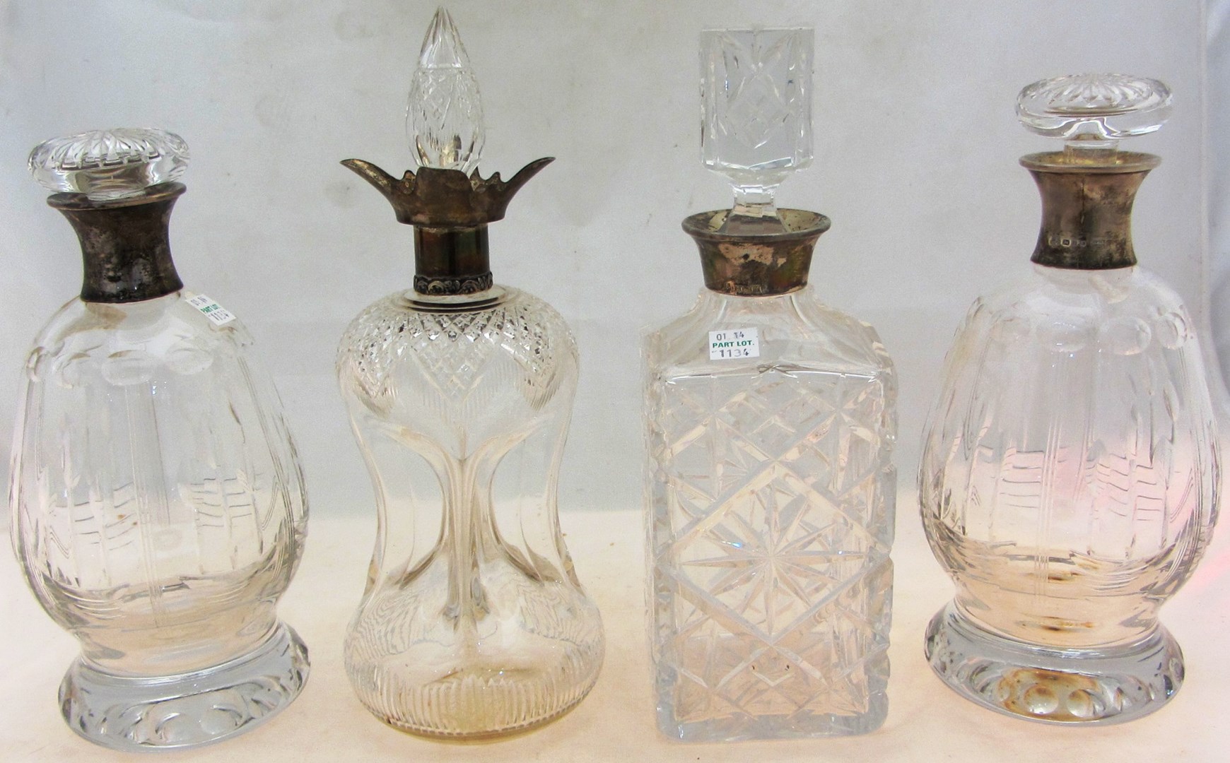 Appraisal: A pair of silver mounted faceted glass decanters each of