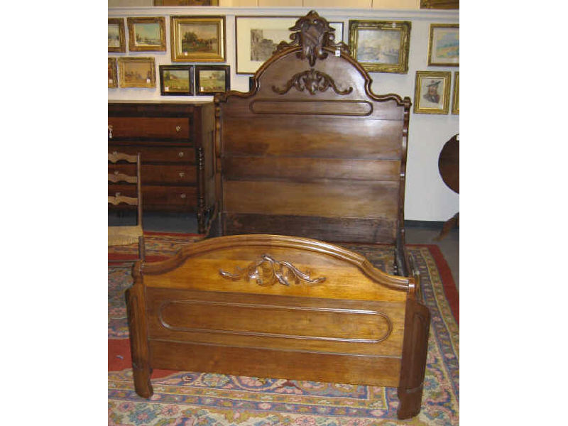 Appraisal: AMERICAN ROCOCO REVIVAL WALNUT BEDSTEAD With elaborate foliate crest centering