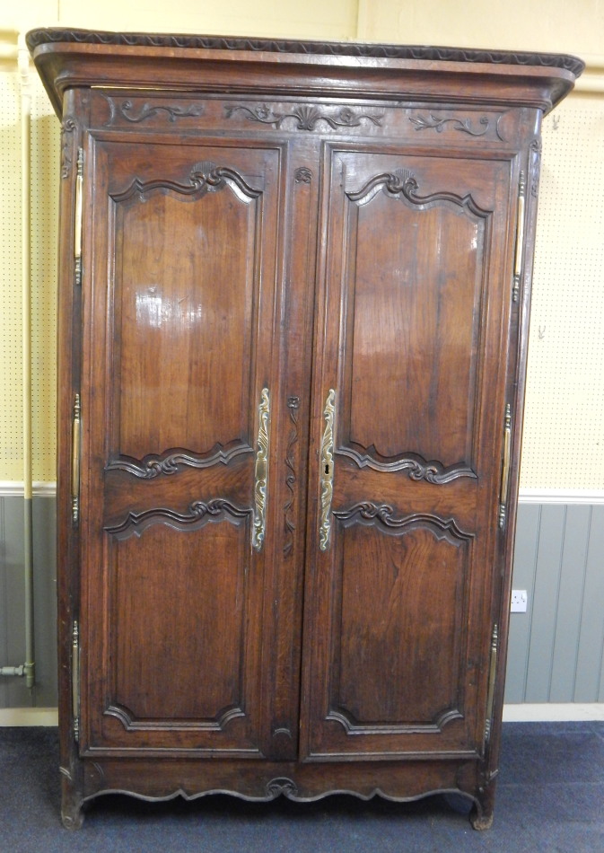 Appraisal: An thC French chestnut armoire with a moulded cornice the