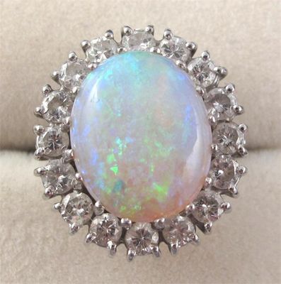 Appraisal: An opal and diamond cluster ring The oval shaped opal