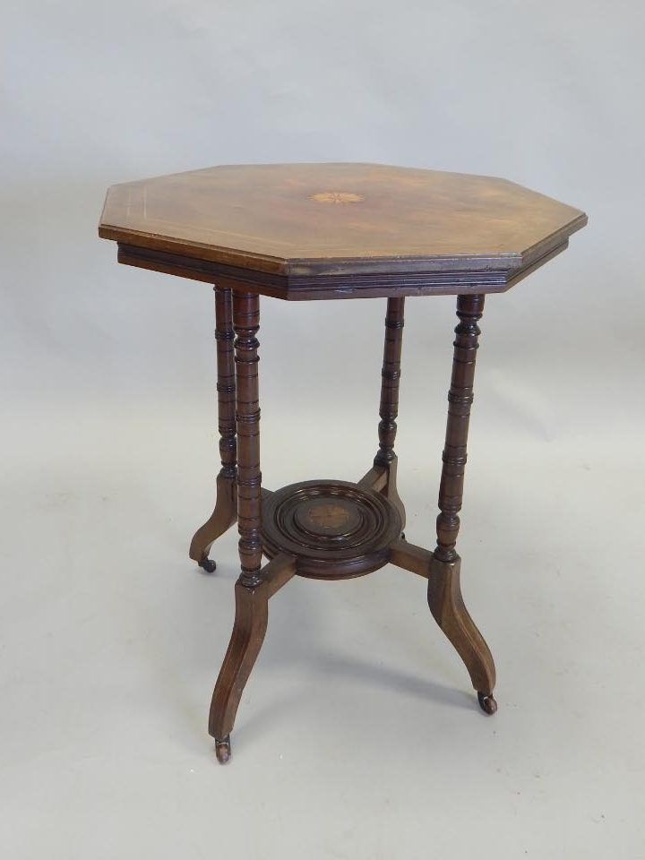 Appraisal: An Edwardian walnut two tier occasional table the octagonal top