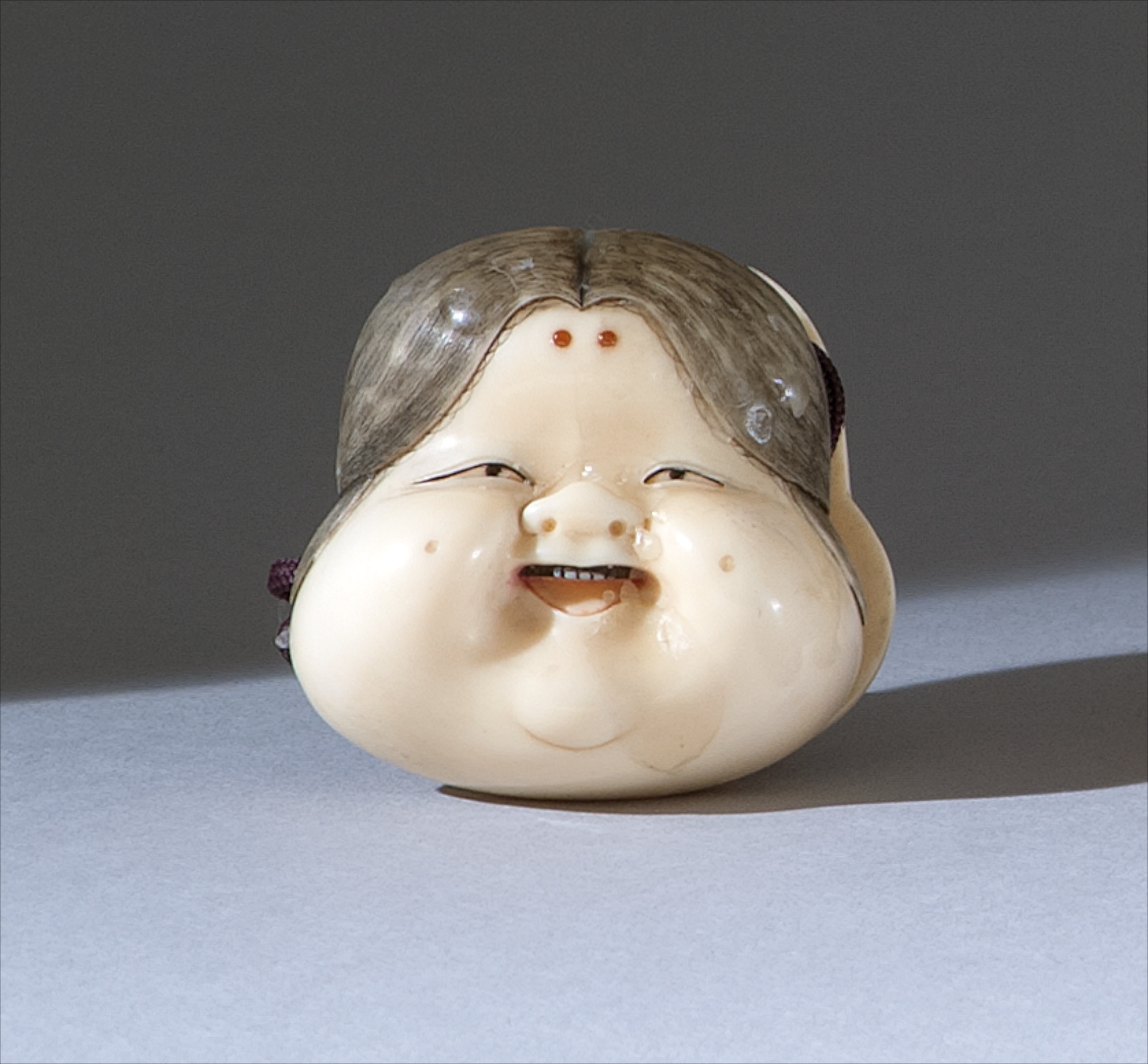 Appraisal: IVORY SHUNGA NETSUKE Meiji PeriodIn the form of a mask