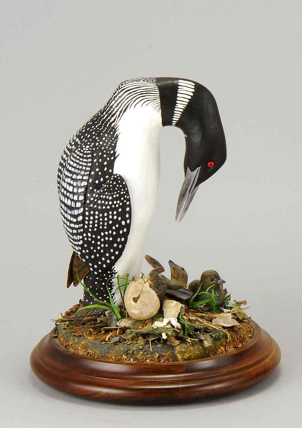 Appraisal: CONTEMPORARY CARVING OF A LOON WITH HATCHING YOUNGSigned illegibly on