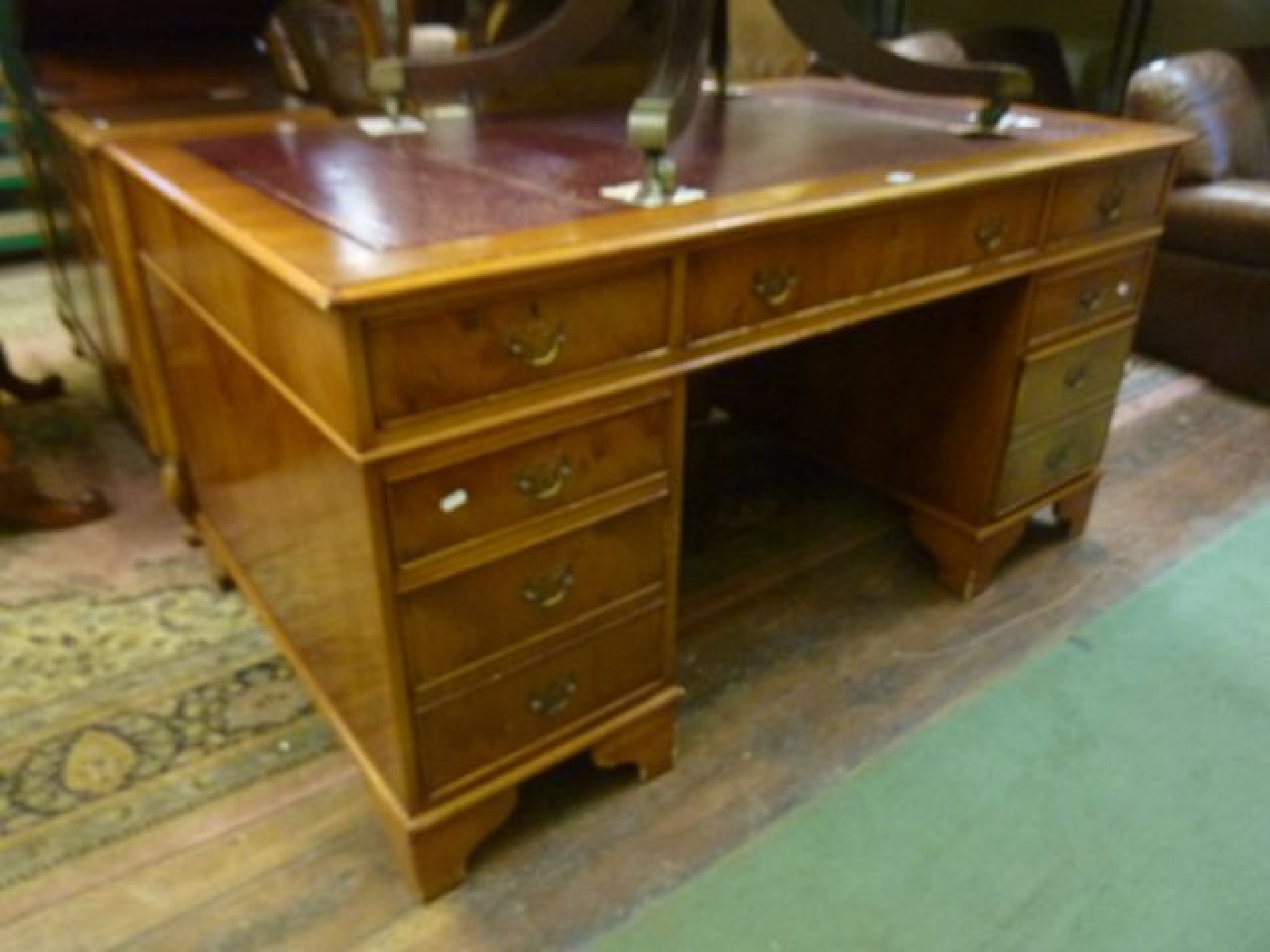 Appraisal: A reproduction pedestal desk with yew wood veneers with inset