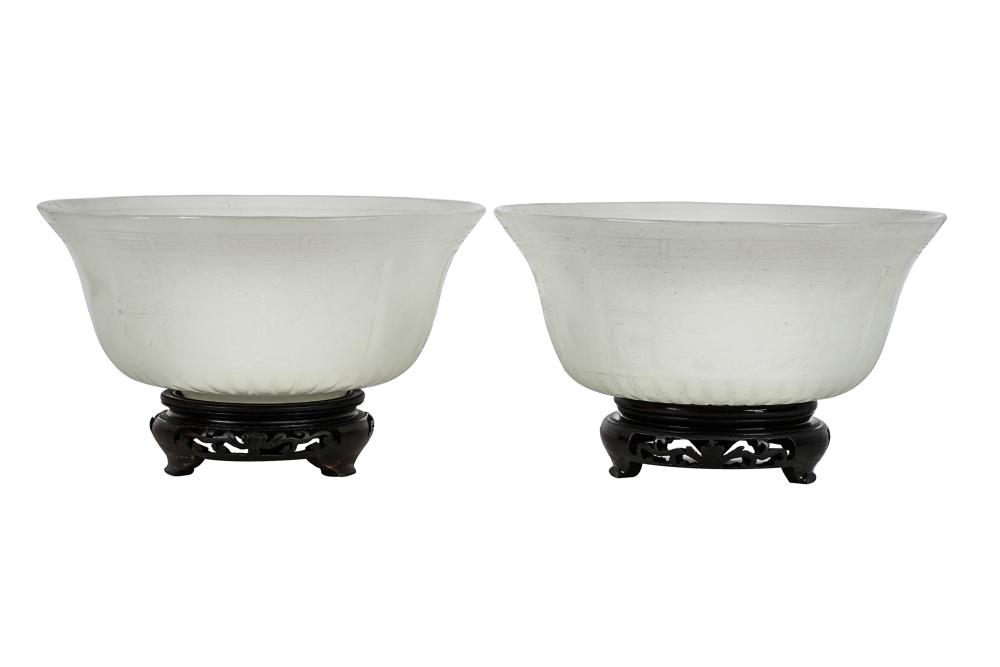 Appraisal: PAIR OF WHITE PEKING GLASS BOWLSrelief-decorated set atop fitted carved