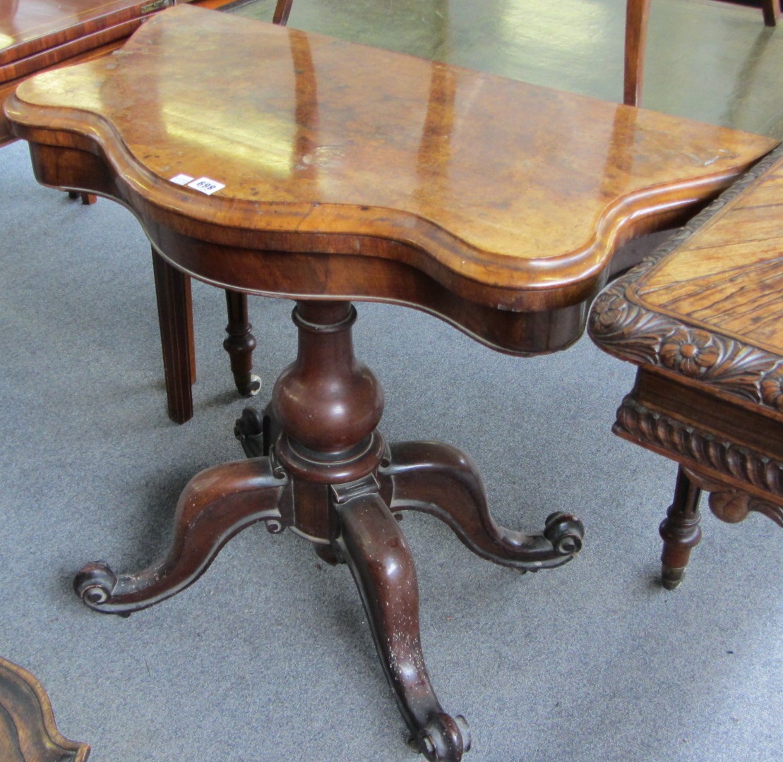 Appraisal: A Victorian figured walnut serpentine card table on turned column