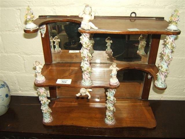 Appraisal: A th Century mahogany wall shelf with continental porcelain supports