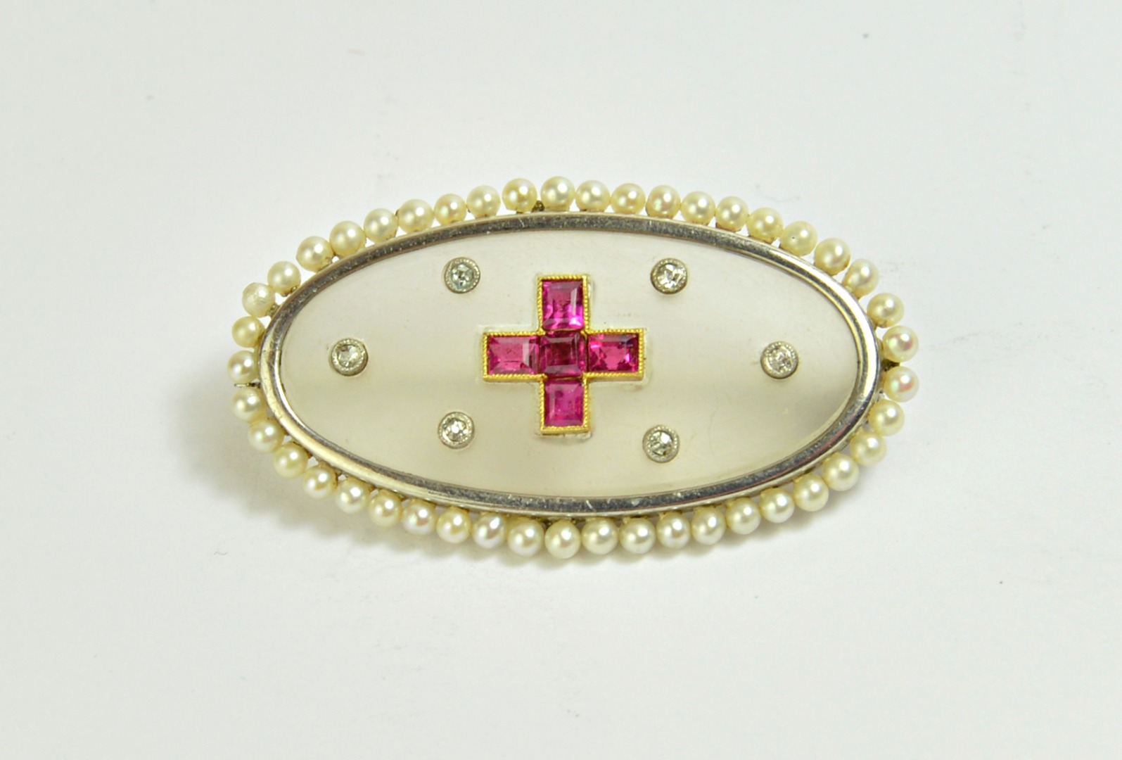 Appraisal: A diamond ruby and seed pearl set brooch of oval