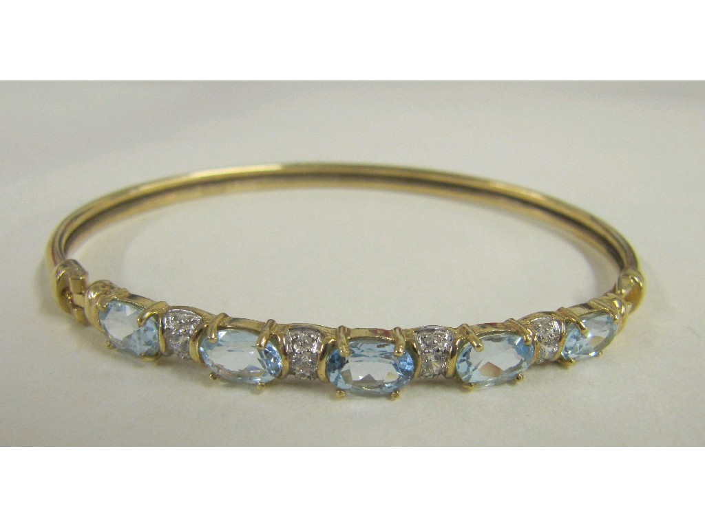 Appraisal: Nine carat gold blue topaz set bangle