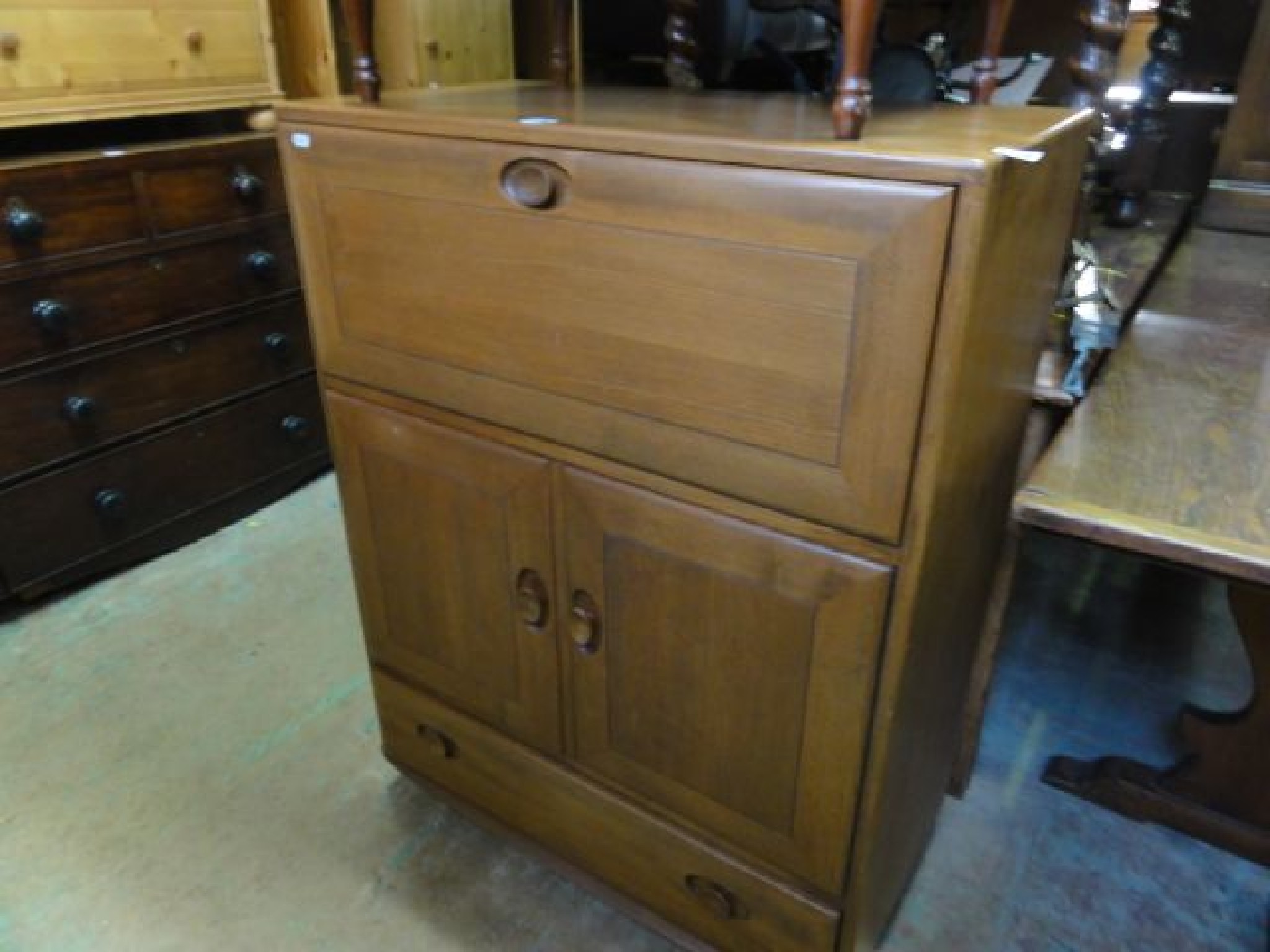 Appraisal: An Ercol medium elm flat top bureau with fall front