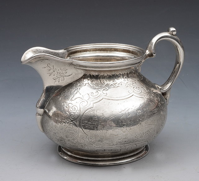 Appraisal: A VICTORIAN SILVER CREAM JUG with engraved scroll decoration and