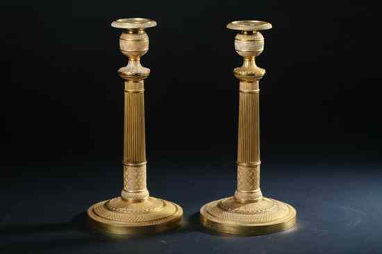 Appraisal: PAIR EMPIRE ORMOLU CANDLESTICKS Circa Circular columnar standard urn-form nozzle