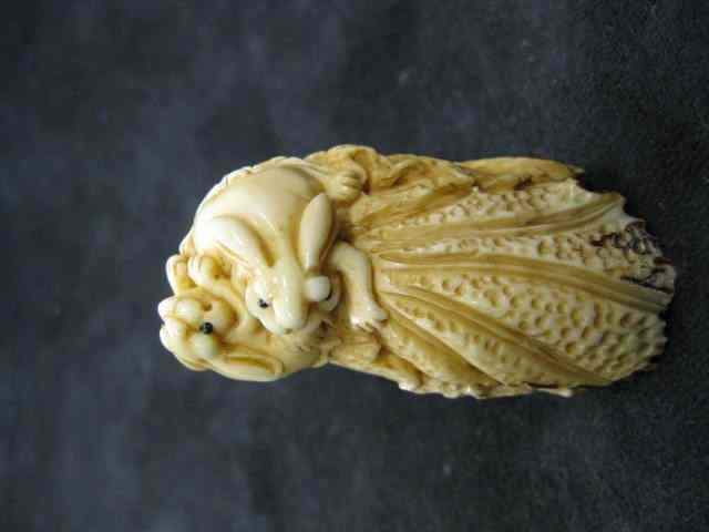 Appraisal: Carved Ivory Netsuke of a Rabbit andcabbage one hiding ''