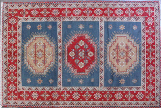 Appraisal: HAND KNOTTED ORIENTAL CARPET Indo-Caucasian featuring three geometric medallions each