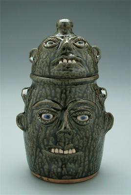 Appraisal: Cleater Meaders two-tier face jug body and lid formed as