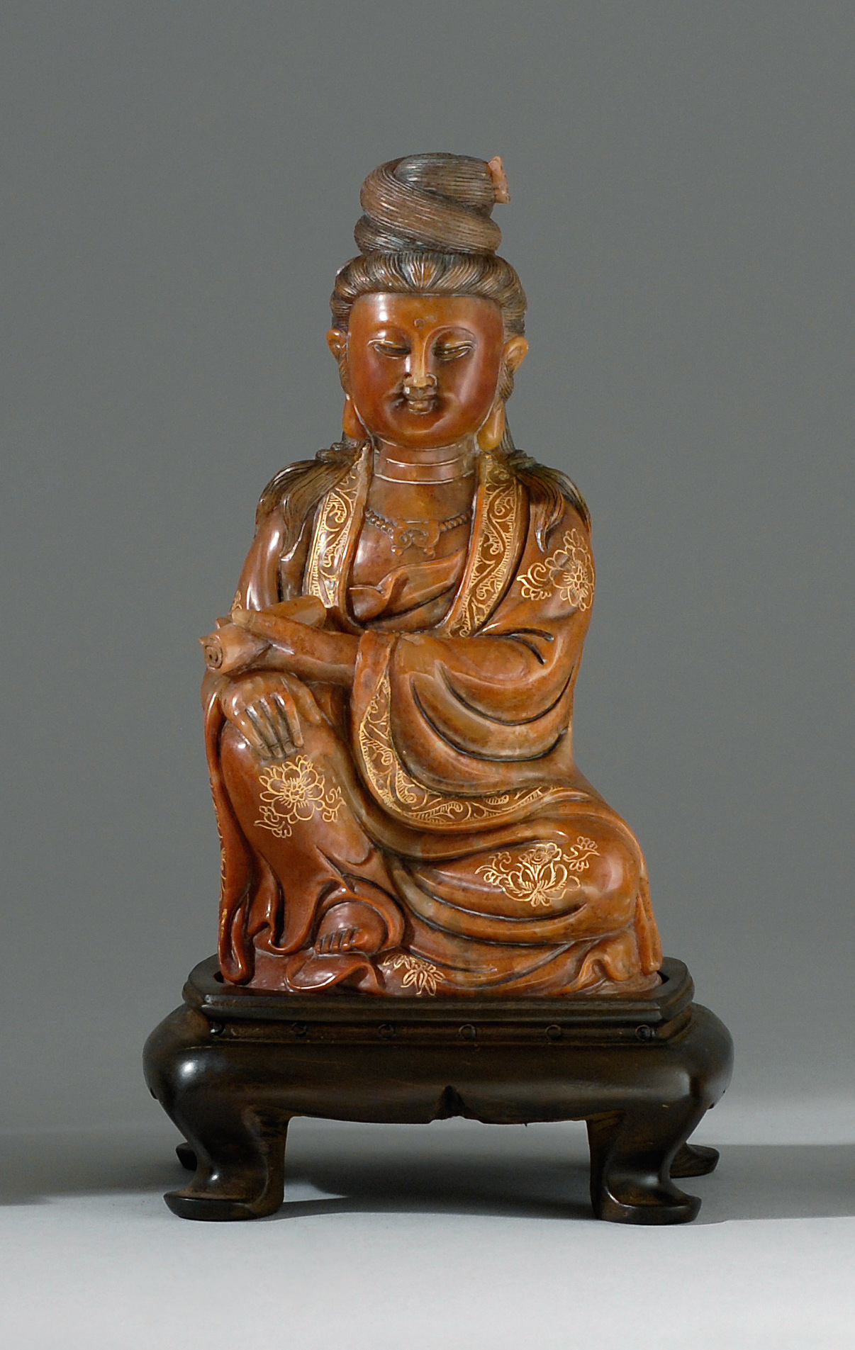 Appraisal: RED-BROWN SOAPSTONE CARVING Early th CenturyDepicting Guanyin seated holding a