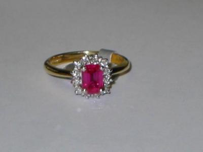 Appraisal: A RUBY AND DIAMOND CLUSTER RING the emerald cut ruby