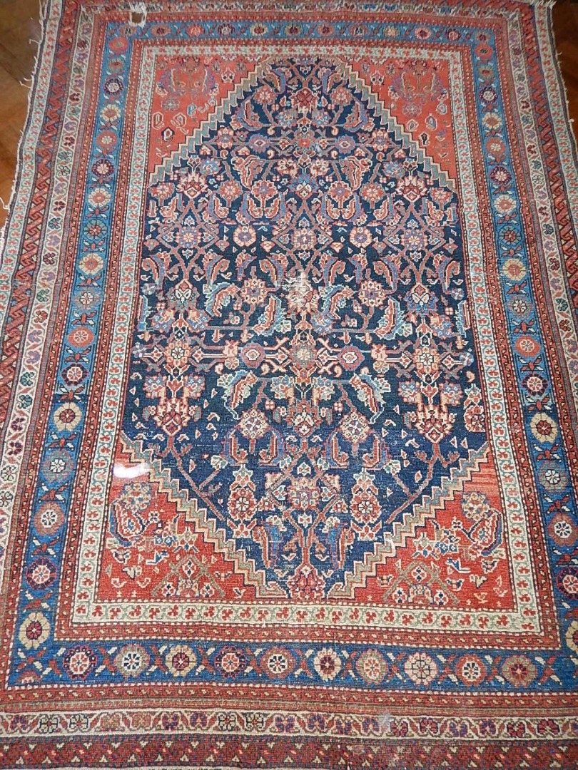 Appraisal: A thC Persian bordered rug in blue and red cm