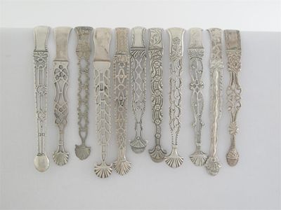 Appraisal: Eleven various pairs of George III cast-arm sugar tongs mainly