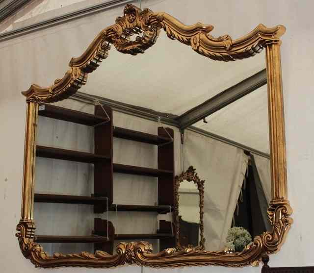 Appraisal: A GILT SHAPED MIRROR with scrolling acanthus leaf decorated top