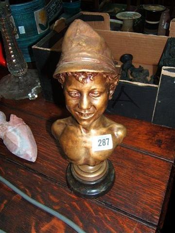 Appraisal: A bronze bust of a young boy wearing a Russian