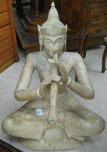 Appraisal: FIGURAL THAI WOOD SCULPTURE the seated male figure playing a