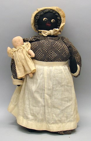 Appraisal: Black cloth mammy style doll Painted features and gray wool