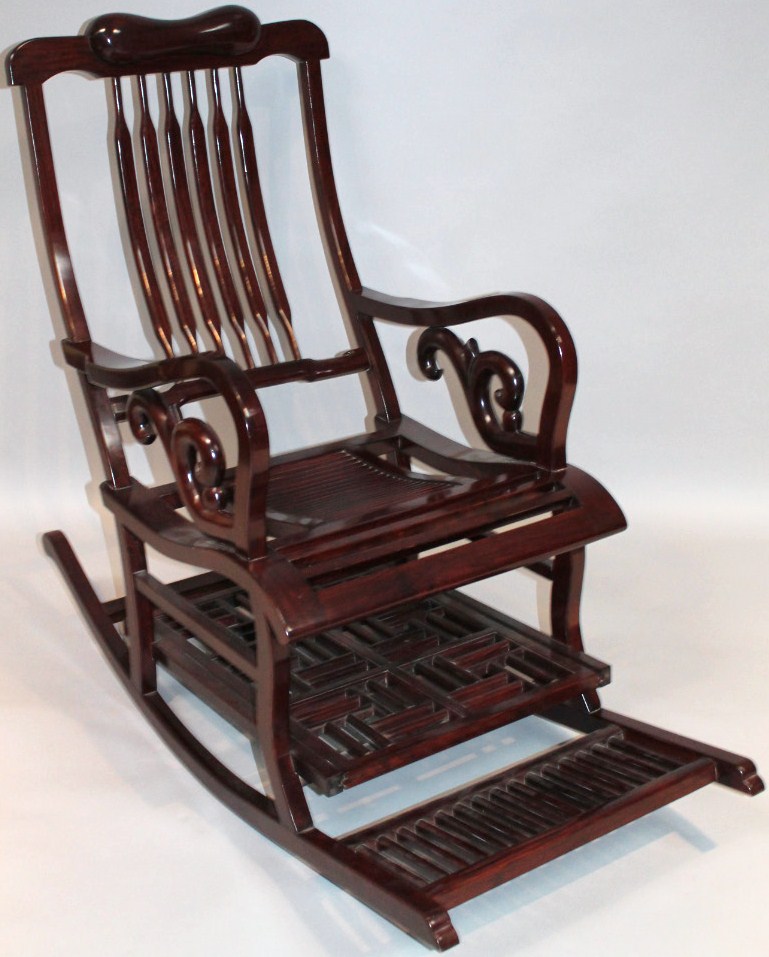 Appraisal: A thC Chinese hardwood rocking chair with a shaped cushion