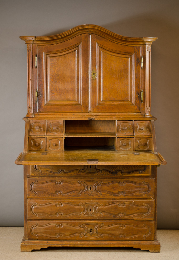 Appraisal: A PROVINCIAL OAK SECRETARY French th century featuring a carved