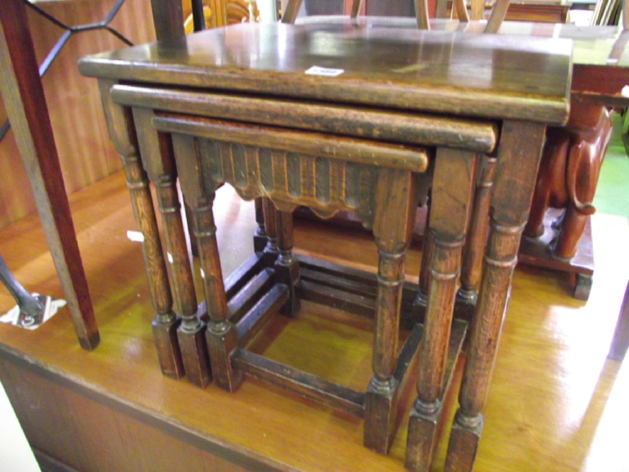 Appraisal: A nest of three graduated oak occasional tables on gun