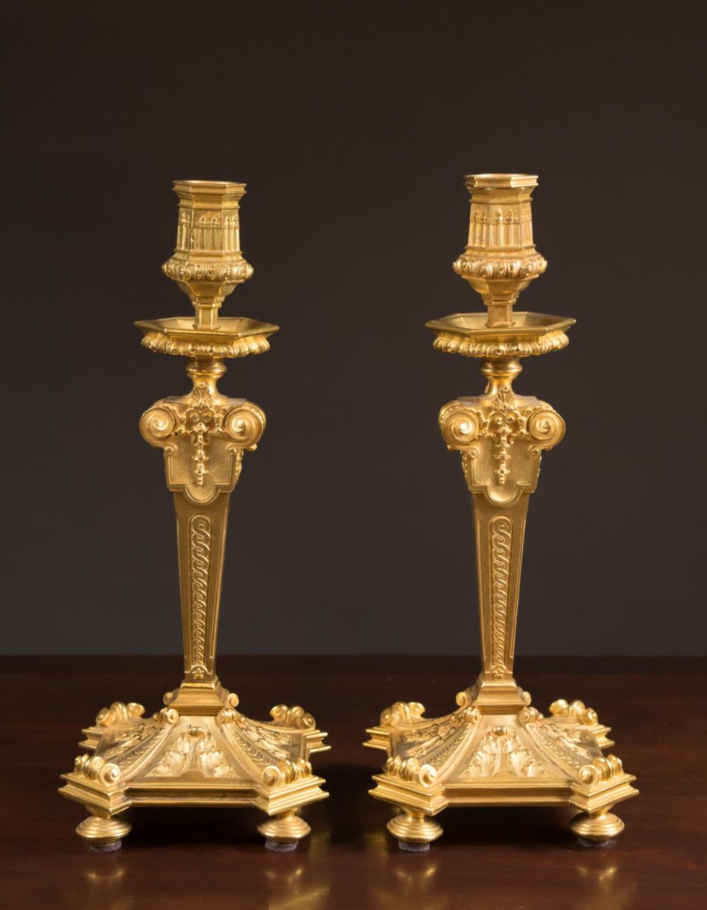 Appraisal: PAIR OF FRENCH GILT BRONZE CANDLESTICKS tapered standards with relief