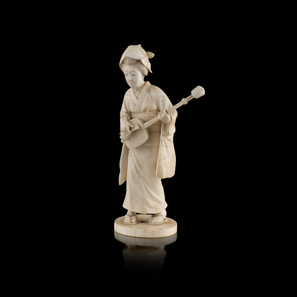 Appraisal: YCARVED IVORY OKIMONO OF A LADY PLAYING A SHAMISEN MEIJI