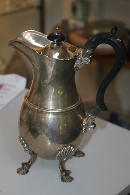 Appraisal: A SILVER WATER JUG with four shell supports hardwood handle