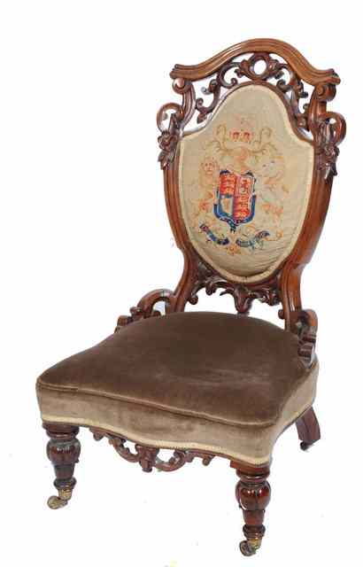 Appraisal: A VICTORIAN WALNUT LOW OCCASIONAL CHAIR with pierced scrolling crest