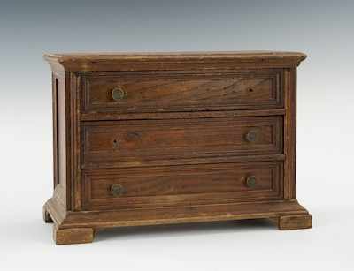 Appraisal: A Miniature Wooden Chest of Drawers The simple darkly stained