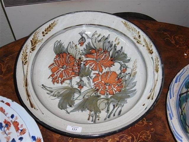 Appraisal: A LARGE STONEWARE CHARGER decorated to the centre with red