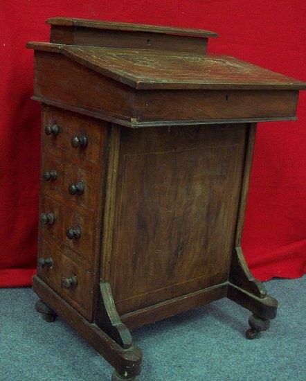 Appraisal: An Edwardian walnut Davenport the hinged stationery compartment above a