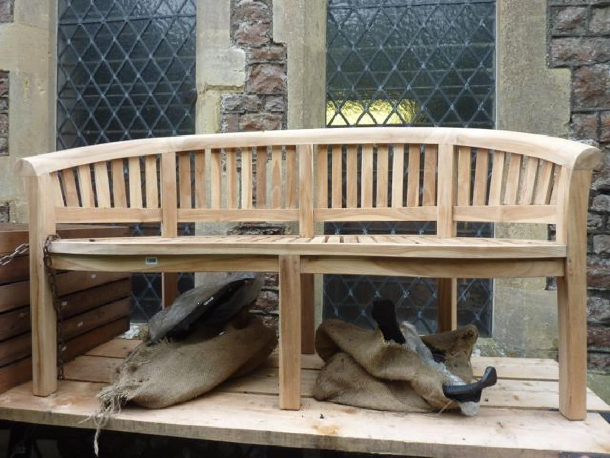 Appraisal: A contemporary teakwood banana bench with slatted seat and back