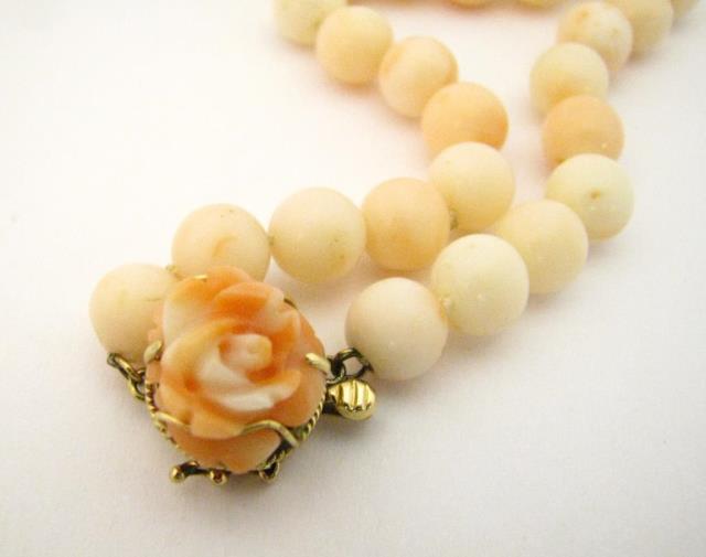 Appraisal: A K yellow gold coral necklace with carved rose clasp