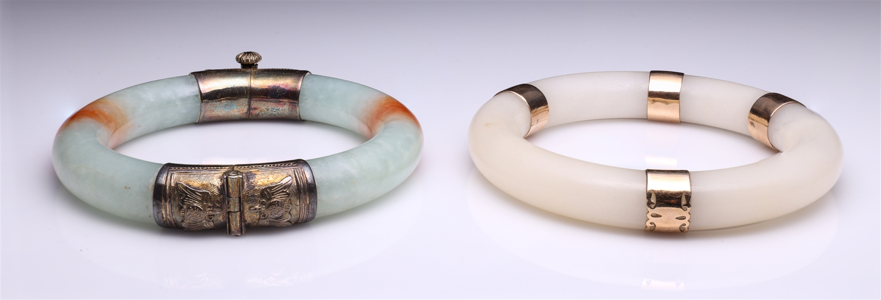 Appraisal: Two Chinese bangles including green and rust colored jadeite mounted