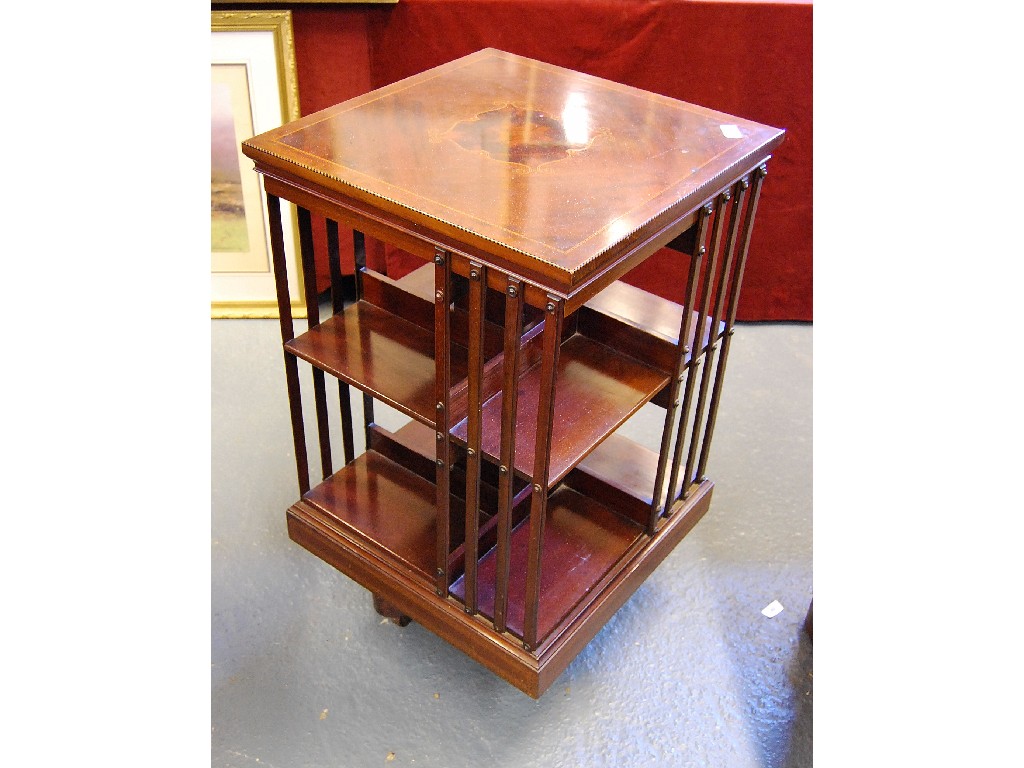 Appraisal: An Edwardian inlaid satinwood two tier revolving bookcase raised on