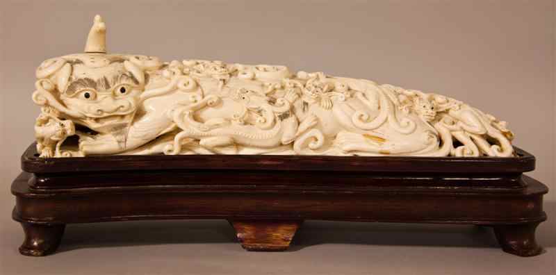 Appraisal: CHINESE IVORY RECUMBANT BUDDHISTIC LION AND CUB the elongated bitch