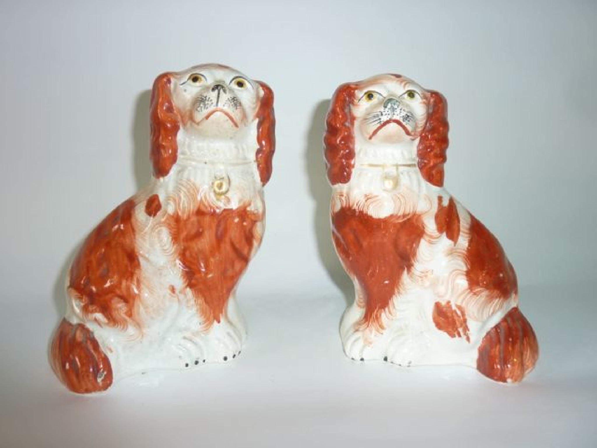 Appraisal: A pair of th century Staffordshire spaniels with rust coloured