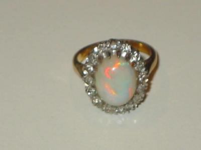 Appraisal: AN OPAL AND DIAMOND CLUSTER RING the cabochon oval centre