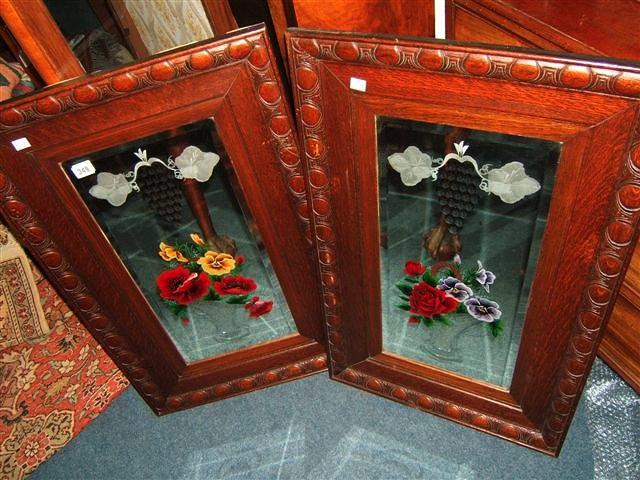 Appraisal: A pair of oak framed bevelled glass mirrors with hand