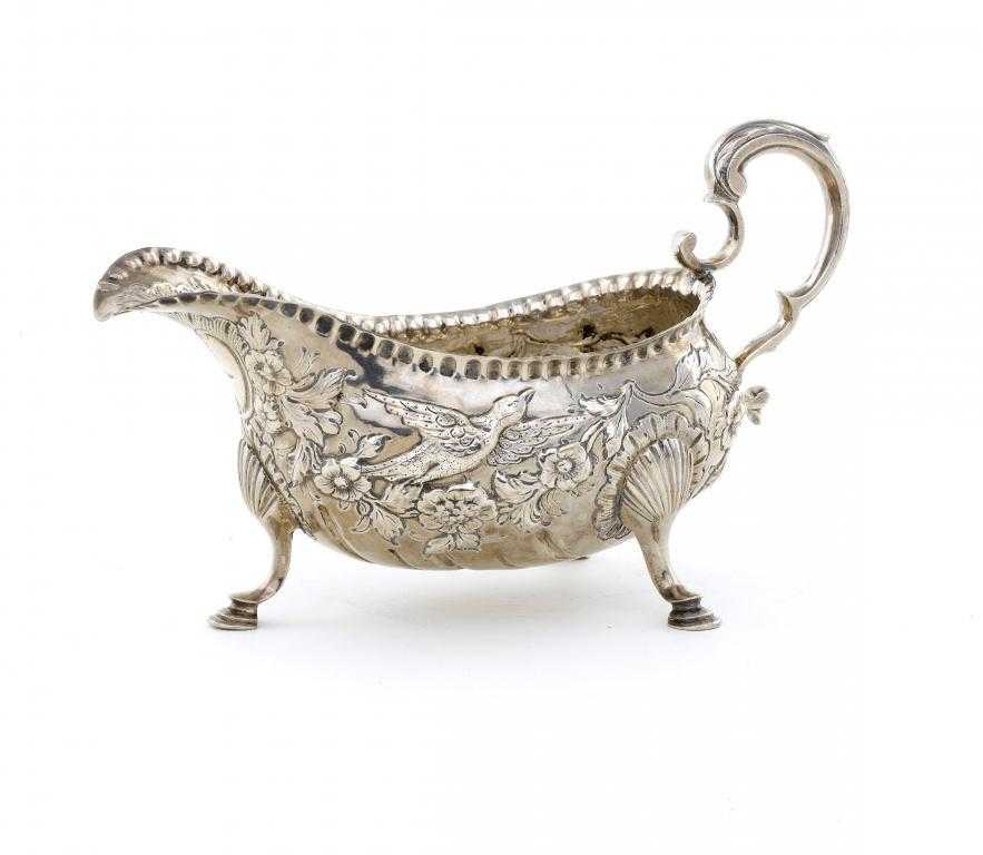 Appraisal: AN IRISH GEORGE III SAUCE BOAT with leaf capped scroll