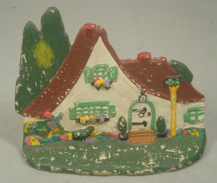 Appraisal: Cast iron doorstop colorful caricature cottage house on grassy base